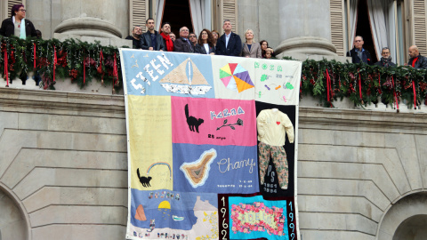 Barcelona desplega el Tapís Memorial de la Sida des del balcó de l’Ajuntament.