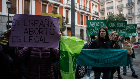 Varias mujeres con carteles protestan junto al Senado, a 2 de diciembre de 2024, en Madrid.