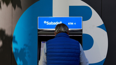 Un hombre opera un cajero automátivo del Banco Sabadell en una de sus oficinas en Madrid. REUTERS/Susana Vera