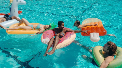 Grupo de personas en una piscina con hinchables fantasía. (Pexels)