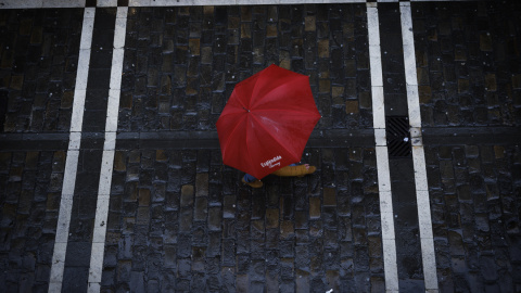 Un viandante se protege de la lluvia en Pamplona (Navarra), en una imagen de archivo.