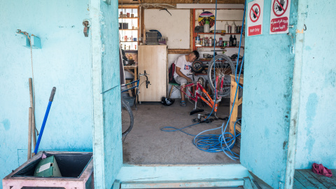 Un niño que asiste al Makerspace en Lesbos mientras intenta arreglar un scooter eléctrico. Lesbos, Grecia