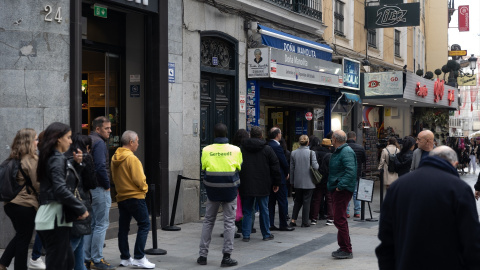 Varias personas hacen cola en la administración de Lotería de Doña Manolita, a 12 de octubre de 2024, en Madrid.