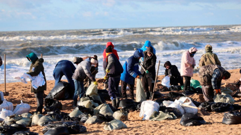 Voluntarios trabajando para limpiar el petróleo derramado en la costa después de un incidente de dos petroleros dañados por una tormenta en el estrecho de Kerch (Rusia)