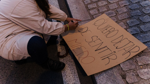 Una mujer pinta un cartel durante el 8M