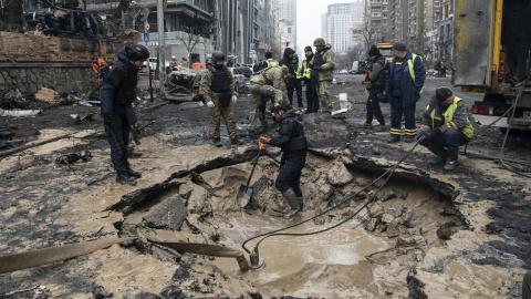 Trabajadores drenan el agua de un agujero tras un bombardeo en el centro de Kiev, Ucrania, a 20 de diciembre de 2024.