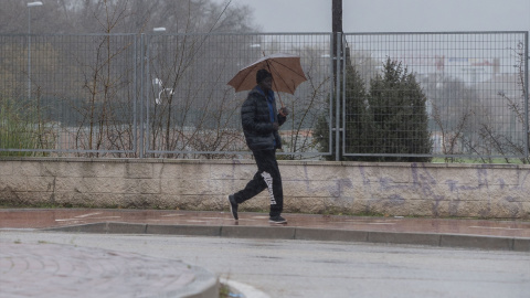 Una persona se protege de la lluvia en Alcalá de Henares, a 19 de enero de 2024.