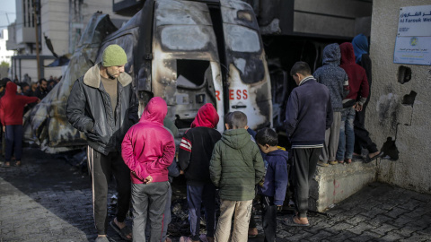 Palestinos inspeccionan un vehículo destruido cerca del hospital Al Awda tras un ataque aéreo israelí en el campamento de refugiados de Al Nuseirat, en el centro de la Franja de Gaza, el 26 de diciembre de 2024.