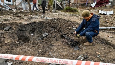 Un hombre toma fotografías de los fragmentos del dron ruso Shahed recogidos en el lugar del impacto en una imagen de archivo.