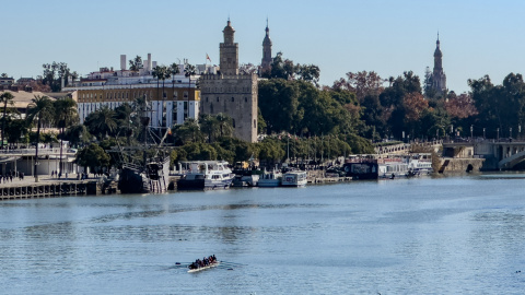 Unos piragüistas navegan por el río Guadalquivir en Sevilla aprovechando el buen tiempo, con cielos despejados y temperaturas cercanas a los 20 grados, del día de Navidad