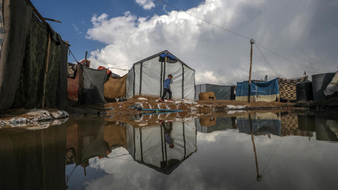 n niño desplazado camina este lunes 30 de diciembre por un campamento en Deir Al Balah, en la Franja de Gaza.