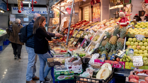 Varias personas hacen compras de última hora en un mercado, a 31 de diciembre de 2024, en Madrid (España).