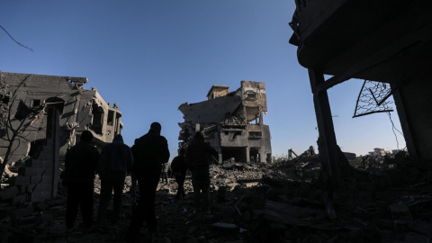 Palestinos inspeccionan las ruinas de una vivienda destruida por los ataques israelíes sobre la Franja de Gaza.