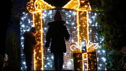 Niños delante de una iluminación de un paquete de regalo, a 11 de diciembre de 2024.