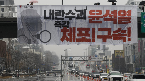 Pancarta con la leyenda "Arresten al líder de la rebelión Yoon Suk Yeol inmediatamente" durante una manifestación contra el presidente surcoreano.