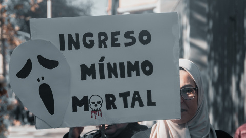 Una mujer sujeta un cartel de protesta durante una concentración convocada por la plataforma RMI Tu Derecho (Renta Mínima de Inserción) en Madrid el pasado 28 de diciembre de 2024.