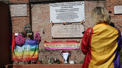 Una mujer con la bandera de la república participa en un homenaje a las 13 Rosas y los 43 Claveles, en el 83º aniversario de su fusilamiento, en el Cementerio de la Almudena.