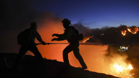 Bomberos de Los Ángeles tratan de apagar las llamas en el incendio que asola el barrio de Pacific Palisades, a 7 de enero de 2024.