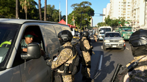 Un militar venezolano revisa los documentos de un conductor en un puesto de control, en Caracas, a 8 de enero de 2025.