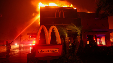 Los bomberos trabajan para extinguir las llamas mientras el incendio arde en Pasadena, California, EEUU.