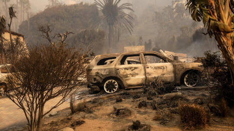 Los restos de un coche carbonizado en un vecindario destruido por el incendio forestal en Malibú, California, EE.UU.