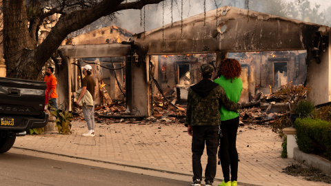 Personas observan una casa afectada por un incendio este miércoles, en Altadena, California, a 8 de enero de 2024.