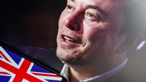 Elon Musk con una bandera del Reino Unido al lado.