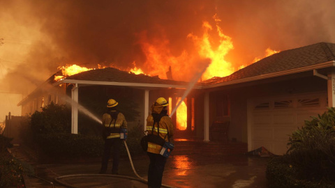 Bomberos intentan combatir el fuego en un barrio de Los Ángeles (California) a 8 de enero de 2025.