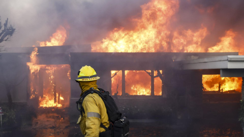 Un bombero apaga las llamas de una vivienda en Los Ángeles, a 7 de enero de 2024.