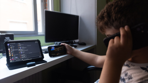 Un niño usa el teléfono móvil y una tablet