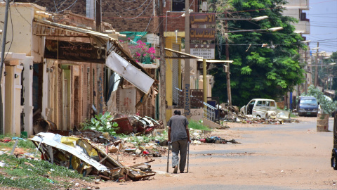 Un hombre camina por una calle marcada por la destrucción, mientras una sangrienta lucha por el poder asola Sudán desde hace más de dos años.