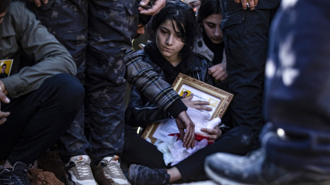 Una niña sostiene un retrato de uno de los dos combatientes kurdos de las Fuerzas Democráticas Sirias (FDS), muertos días antes en un combate contra las fuerzas sirias apoyadas por Turquía en la ciudad norteña de Manbij, durante su funeral en Qamishli.