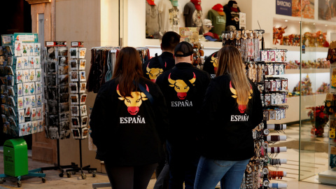 Un grupo de turistas, con sudaderas con una imagen de un toro con los colores de la bandera española, en una tienda de souvenirs, en la localidad malagueña de Rondas.