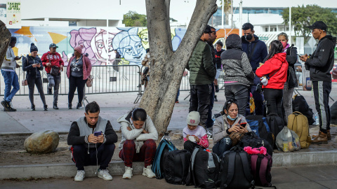 Migrantes deportados descansan en un anden en el puerto fronterizo de El Chaparral, en Tijuana (México), a 22 de enero de 2025.