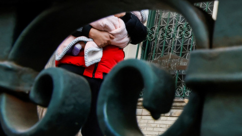 Un hombre sostiene a un bebé mientras espera para entrar a la Iglesia Metodista Unida de San Pablo y San Andrés, en Nueva York.