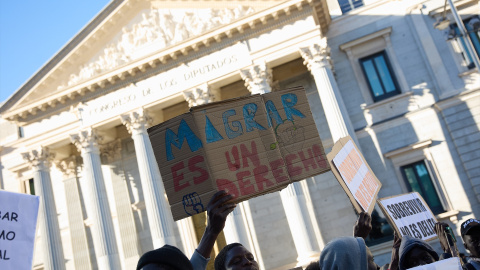 Varias personas se concentran frente al Congreso en defensa de la ILP de regularización de migrantes en abril de 2024.