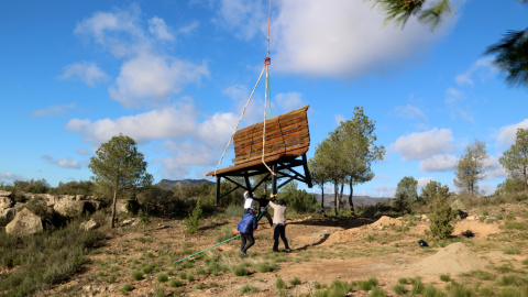 Un grup d'homes sostè el descens del banc gegant al mirador de Vall de Porcs de Riba-roja d'Ebre