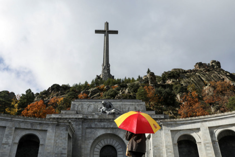 Una mujer con un paraguas con los colores de la bandera española, en el Valle de los Caídos. REUTERS/Susana Vera