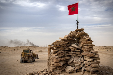  Imagen de archivo del 23 de noviembre de 2020 de una excavadora y una bandera de Marruecos en la carretera ubicada en El Guerguerat, frontera del Sáhara Occidental.- AFP