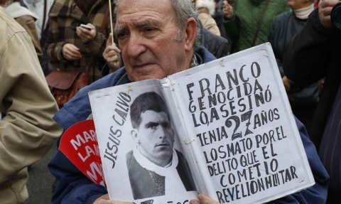  Un hombre muestra una foto de una víctima del franquismo en una concentración en la Puerta del Sol.- EFE/Archivo