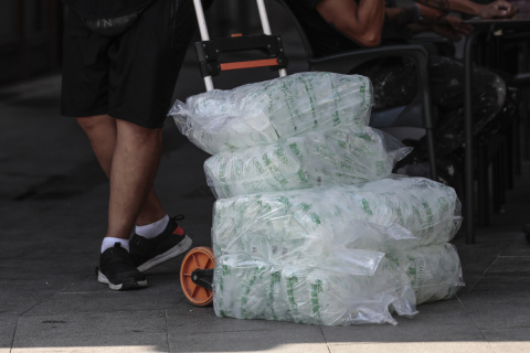  GRAFCVA7539. VALENCIA, 04/08/2022.- Un repartidor lleva una carretilla cargada con bolsas de hielo a un bar este jueves en Valéncia. . EFE/Ana Escobar