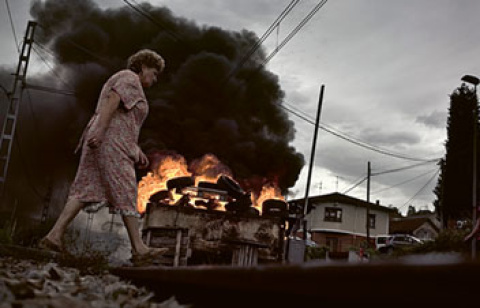  Una mujer pasa por delante de una barricada que corta las vías en Pola de Laviana, cuencas mineras, Asturias, 2012.- JOSÉ COLÓN