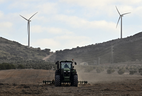  Fotografía: Un tractor labra un campo frente a los aerogeneradores del parque eólico Romeral de Toledo, 2023.- ÓSCAR DEL POZO VIA AFP.