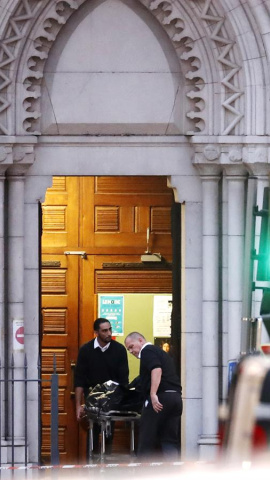 El cuerpo de una víctima es transportado fuera de la iglesia de la Basílica de Notre Dame por oficiales en Niza, Francia.