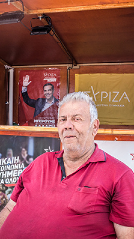 Panagiotis Founis, miembro de Syriza y residente de Lesbos, se sienta en el stand electoral central de su partido en la plaza Safo. Mitilene, Lesbos.