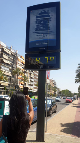 Una joven fotografía un termómetro de calle que marca 47 grados en el centro de Córdoba durante la primera ola de calor de 2023.