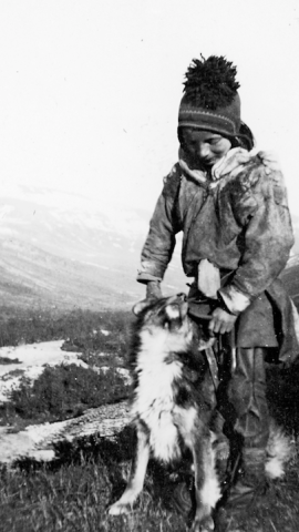 26/11/2021 Un niño sami posa junto a su perro en un paisaje inversal