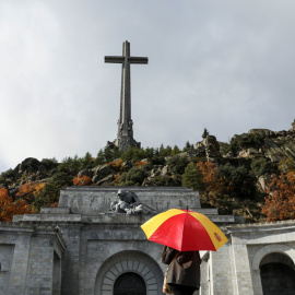 Una mujer con un paraguas con los colores de la bandera española, en el Valle de los Caídos. REUTERS/Susana Vera