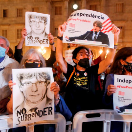 Varias personas sostienen retratos del expresidente de la Generalitat Carles Puigdemont durante las fiestas de la Mercé, de Barcelona. EFE/Marta Pérez