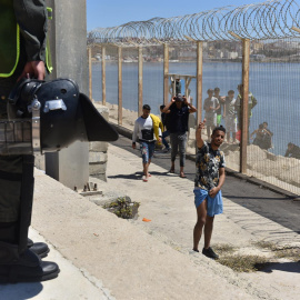  La policía antidisturbios marroquí monta guardia para evitar el paso de personas en la carretera entre Fnidq cerca de la ciudad española de Ceuta, el 19 de mayo de 2021.- EFE